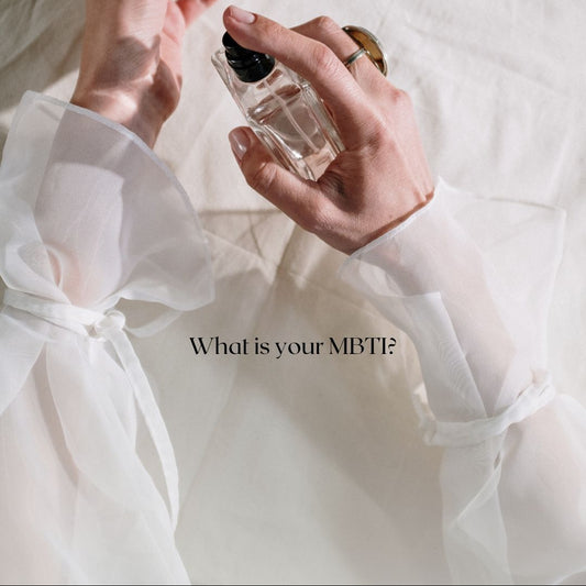 Person holding a small bottle of perfume with a white background and text asking 'What is your MBTI?'.