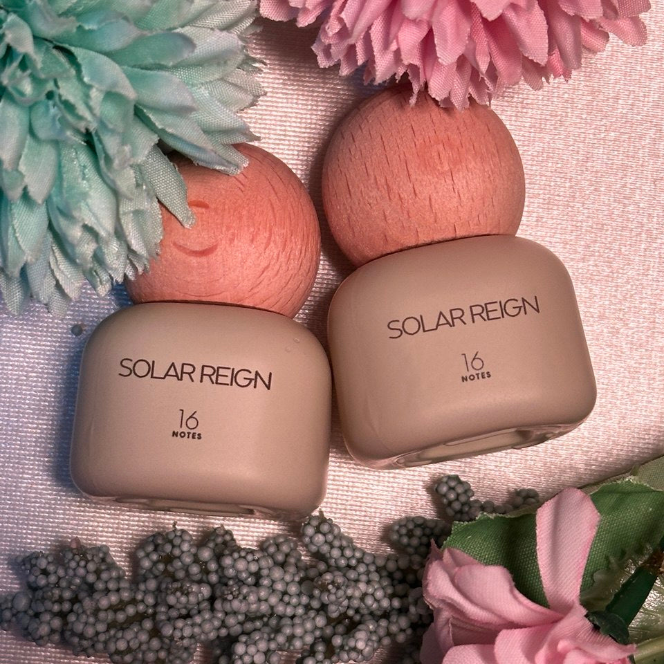 Two beige containers labeled 'Solar Reign' with flowers in the background on a textured surface.