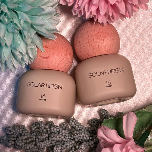 Two beige containers labeled 'Solar Reign' with flowers in the background on a textured surface.
