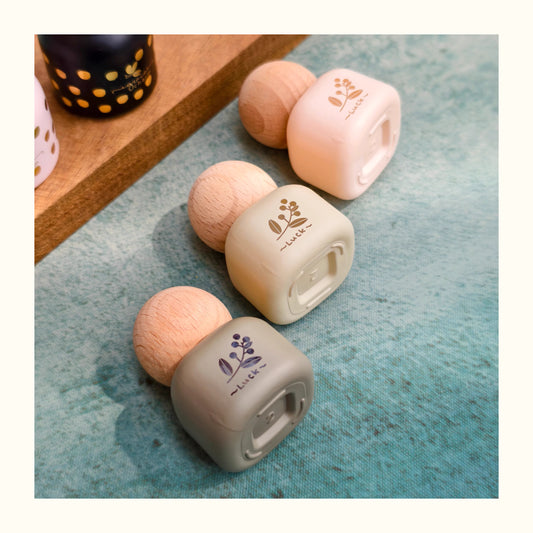 Small round containers with floral designs on a textured surface